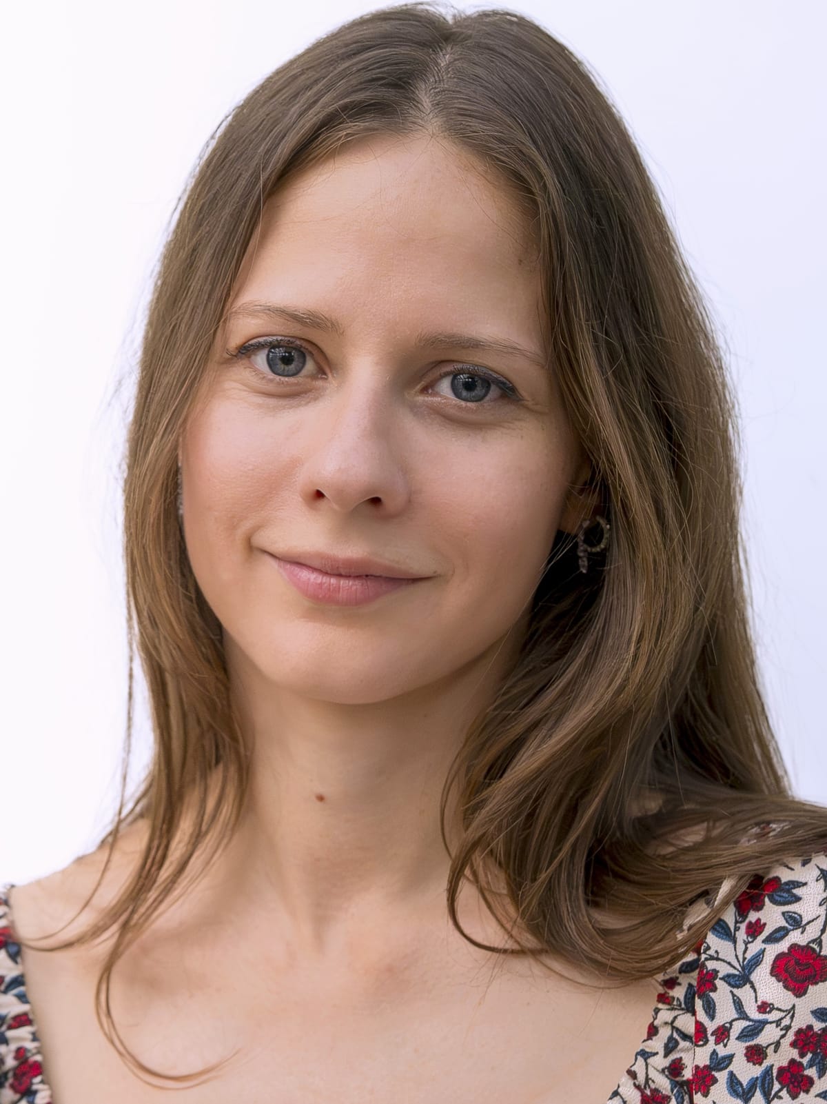 Portrait de Blandine Naudin, psychopraticienne, souriante sur fond neutre.